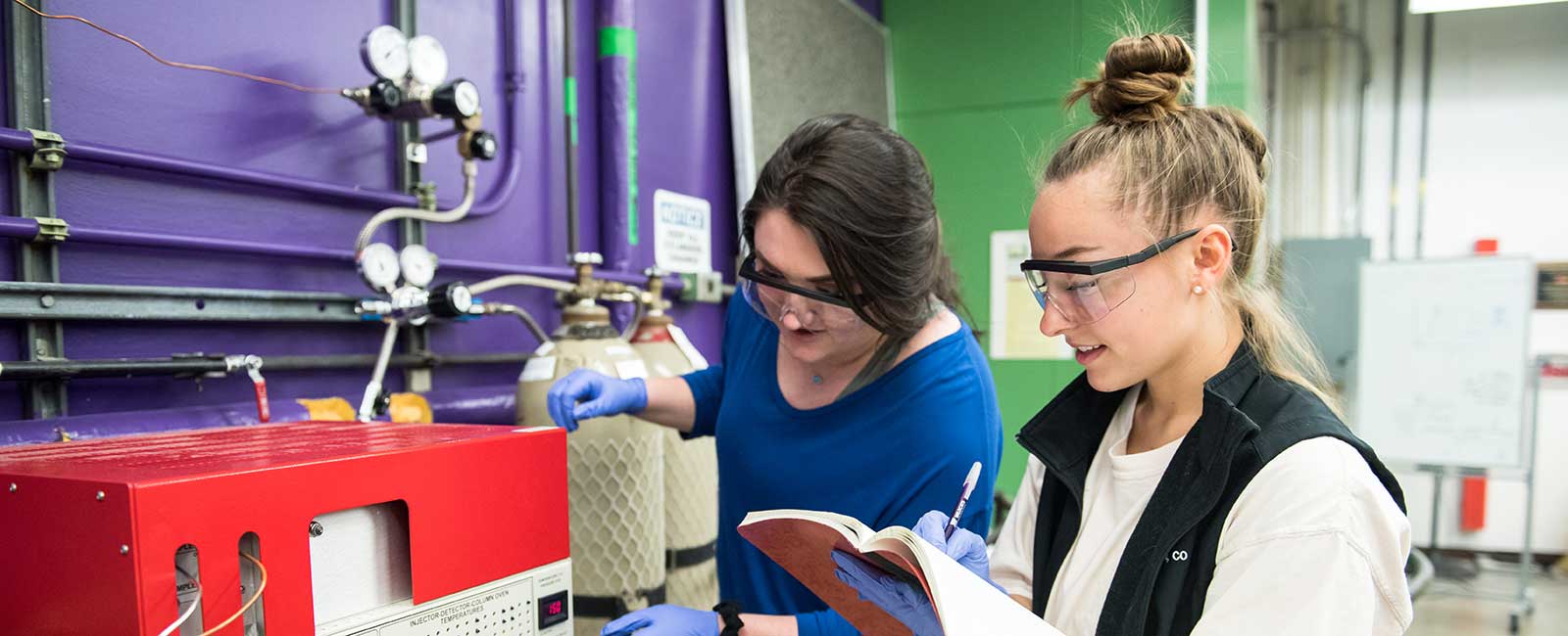 Two students recording data in a lab. 